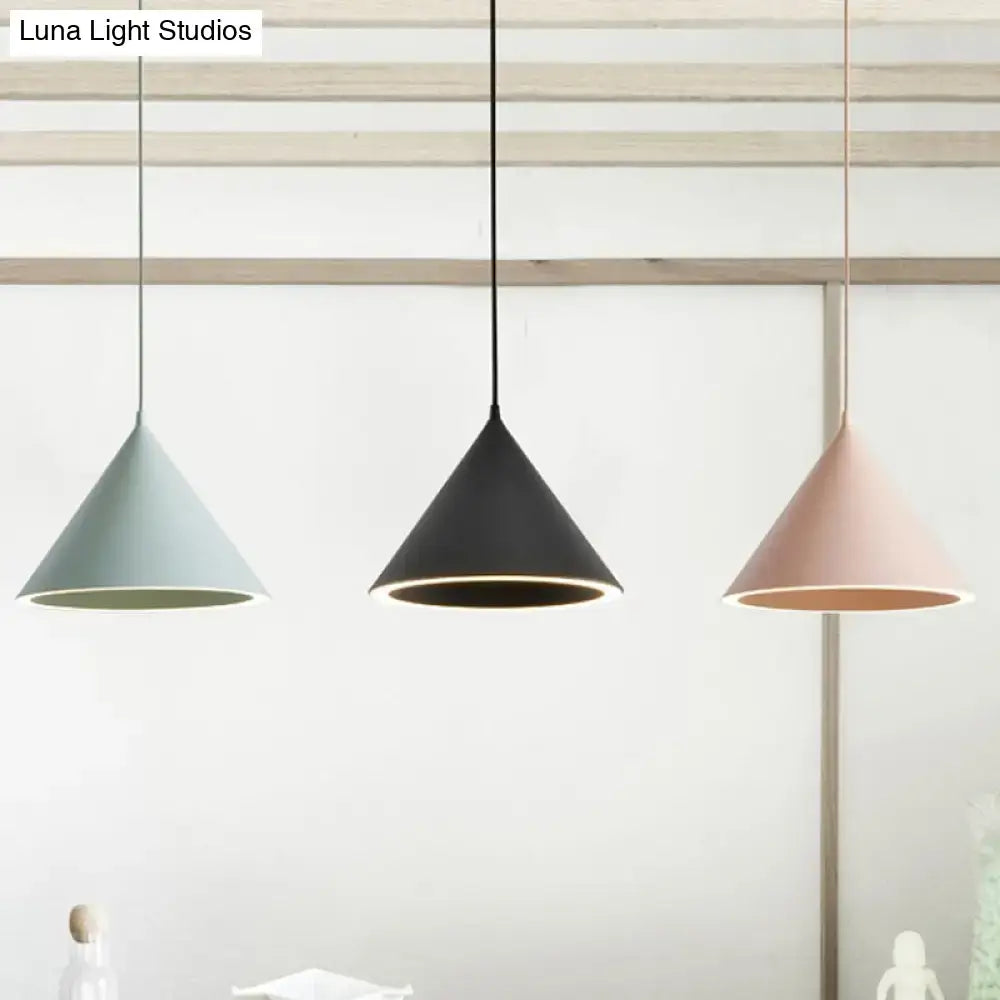 Three matte pastel green black and blush pink nordic stylish pendant lights hang as modern conical hanging lamps