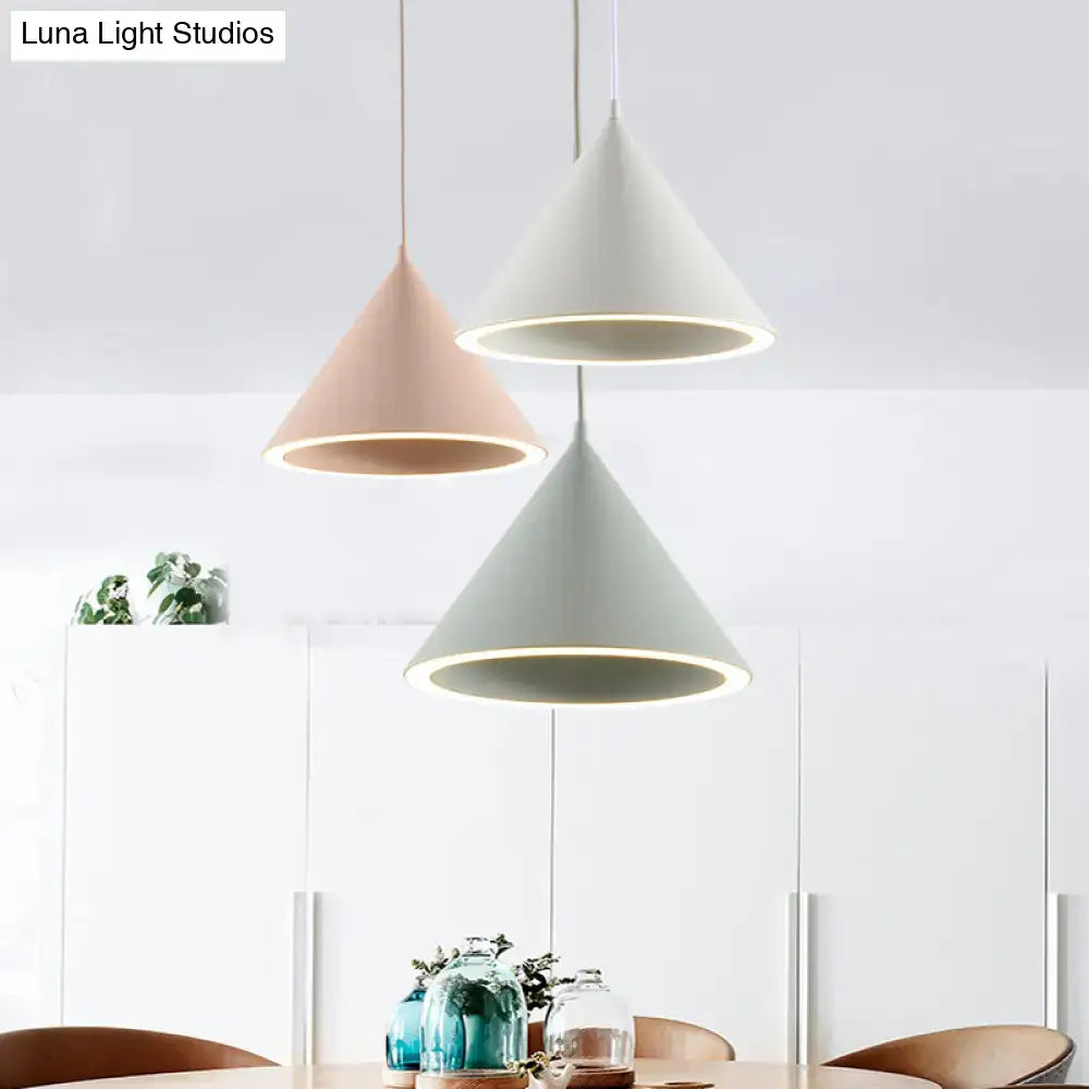 Three modern cone-shaped nordic stylish pendant lights in pastel pink white and gray hanging lamp over table