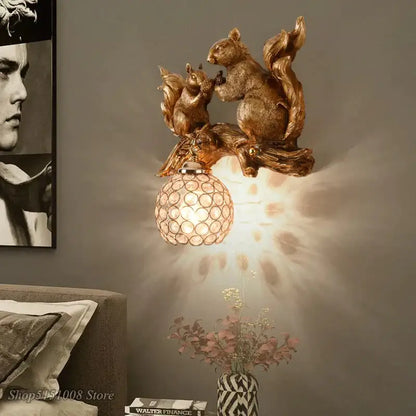 Nordic vintage style wall lamp featuring a golden resin squirrel with a faceted crystal globe shade for bedroom use