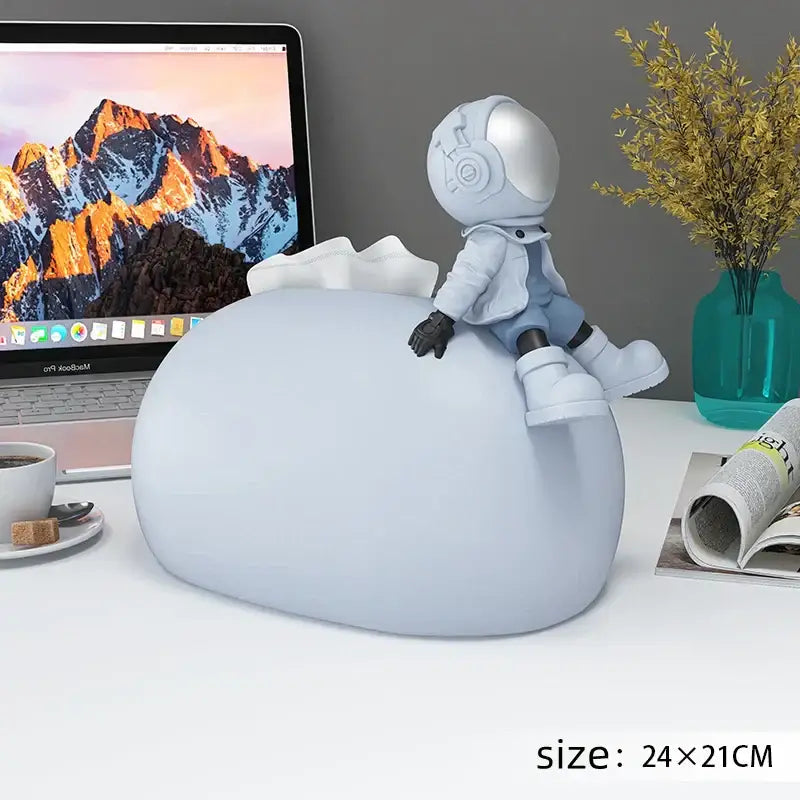 A sleek light gray astronaut figurine on a Nordic white ceramic bear statues tissue box for living room decor