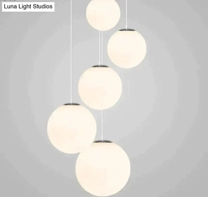 Modern nordic white glass ball pendant lights with frosted glass shades and sleek metal fixtures for living room use