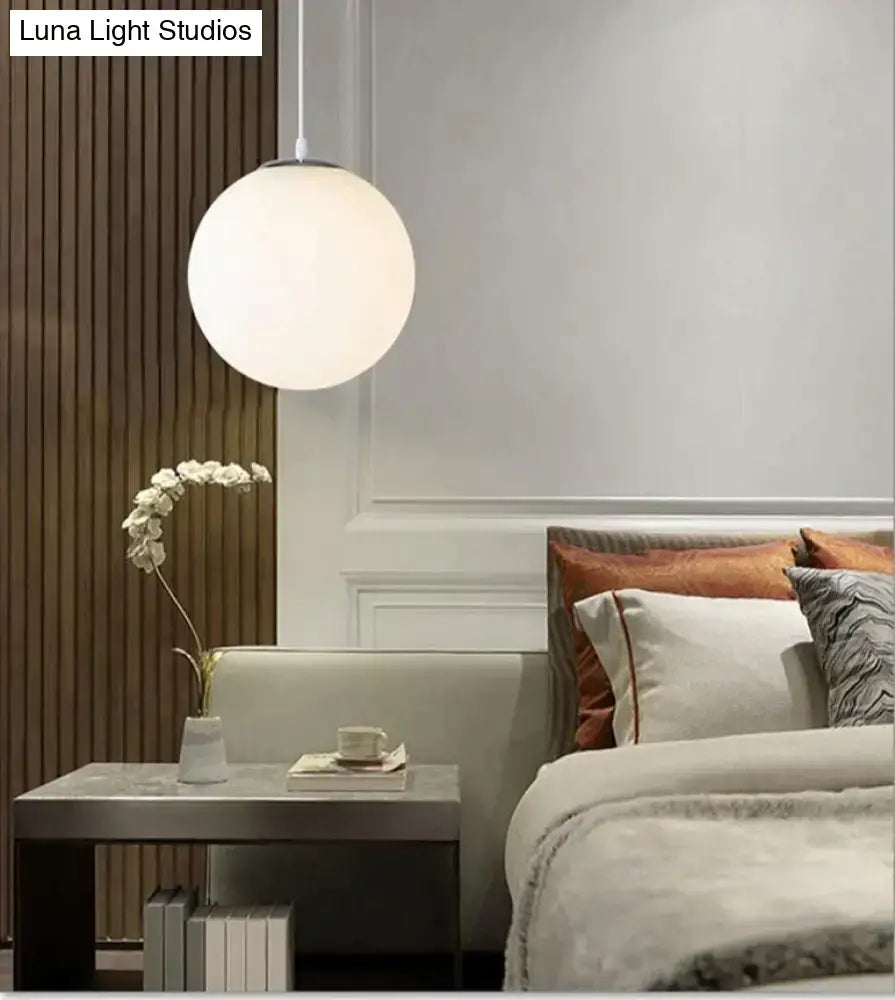 A sleek matte nordic white glass ball pendant light with minimalist design for modern living rooms and bars