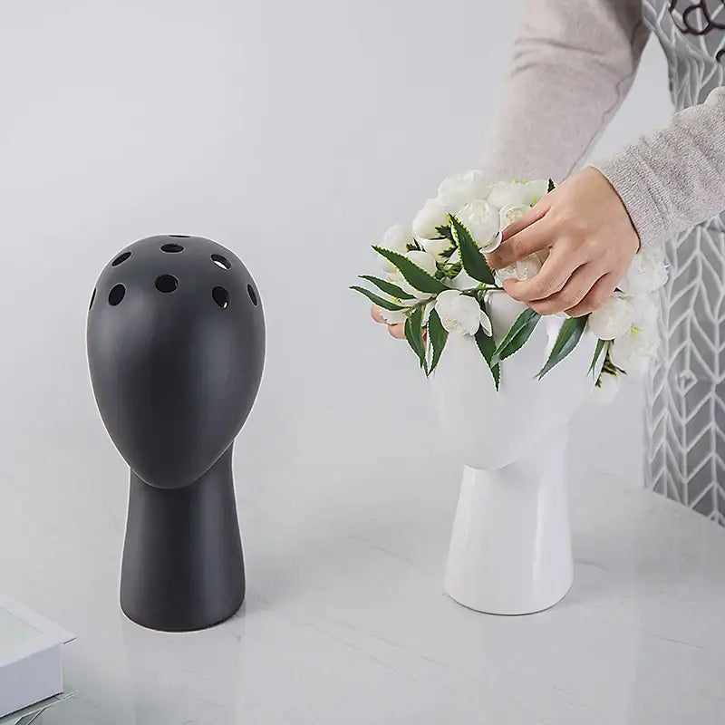Black ceramic human head vase with circular openings for living room decorbites human head ceramic vase decor