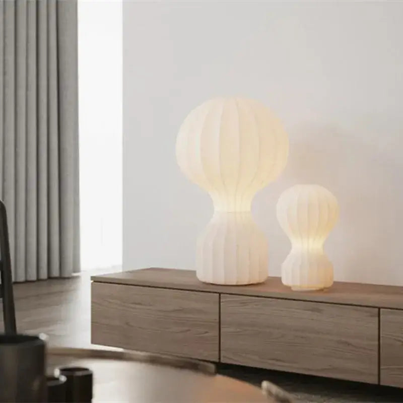Two cream-colored nordic white ribbed hot air balloon table lamps by decorbites gatto silk on wooden console