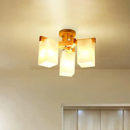 Nordic wood ceiling lamp with warm-toned finish and three cuboid cream glass shades for living room lighting