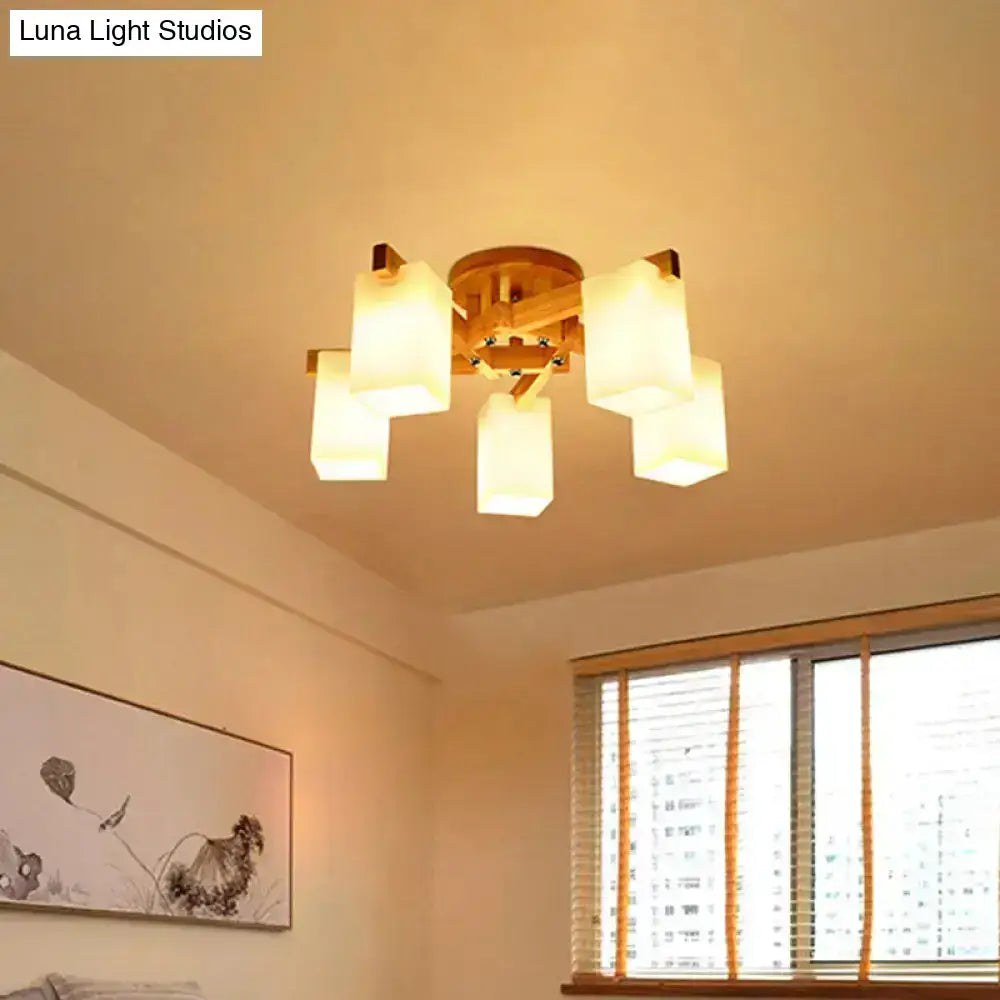 Warm-toned wooden ceiling lamp with five cuboid cream glass shades for living room lighting