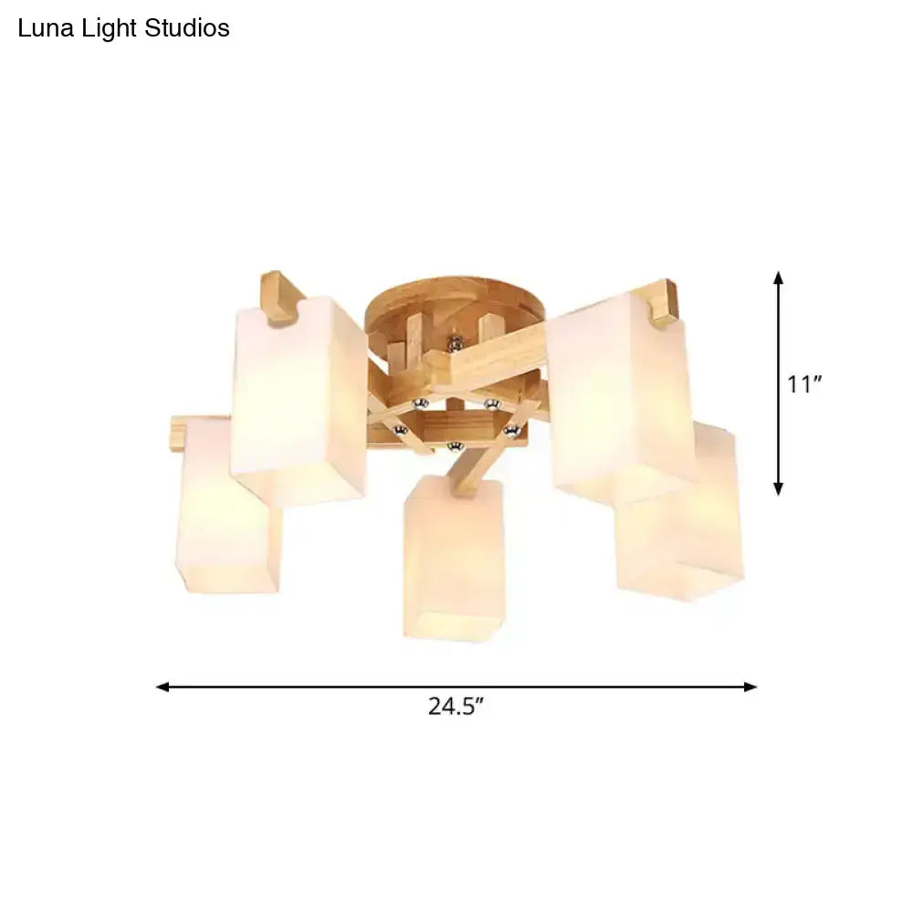 A modern ceiling lamp with a natural wood frame and five cuboid cream glass shades for living room lighting
