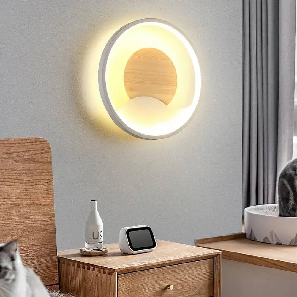 Modern nordic wood and led wall light with white ring and central wooden disc providing warm bedroom decorbites led wall glow