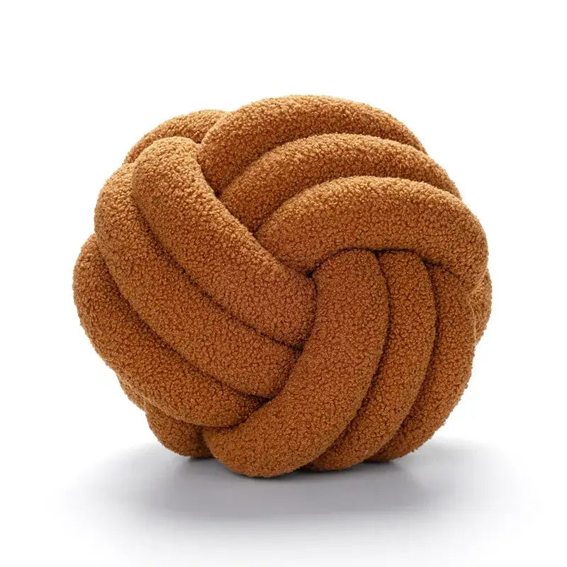 A caramel-colored plush rope knotted circle pillow made of decorbites boucle knotted fabric for bedroom decor