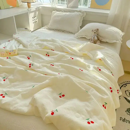Off-white cream-colored double layer yarn summer quilt with quilted texture and embroidered red cherries and green stems