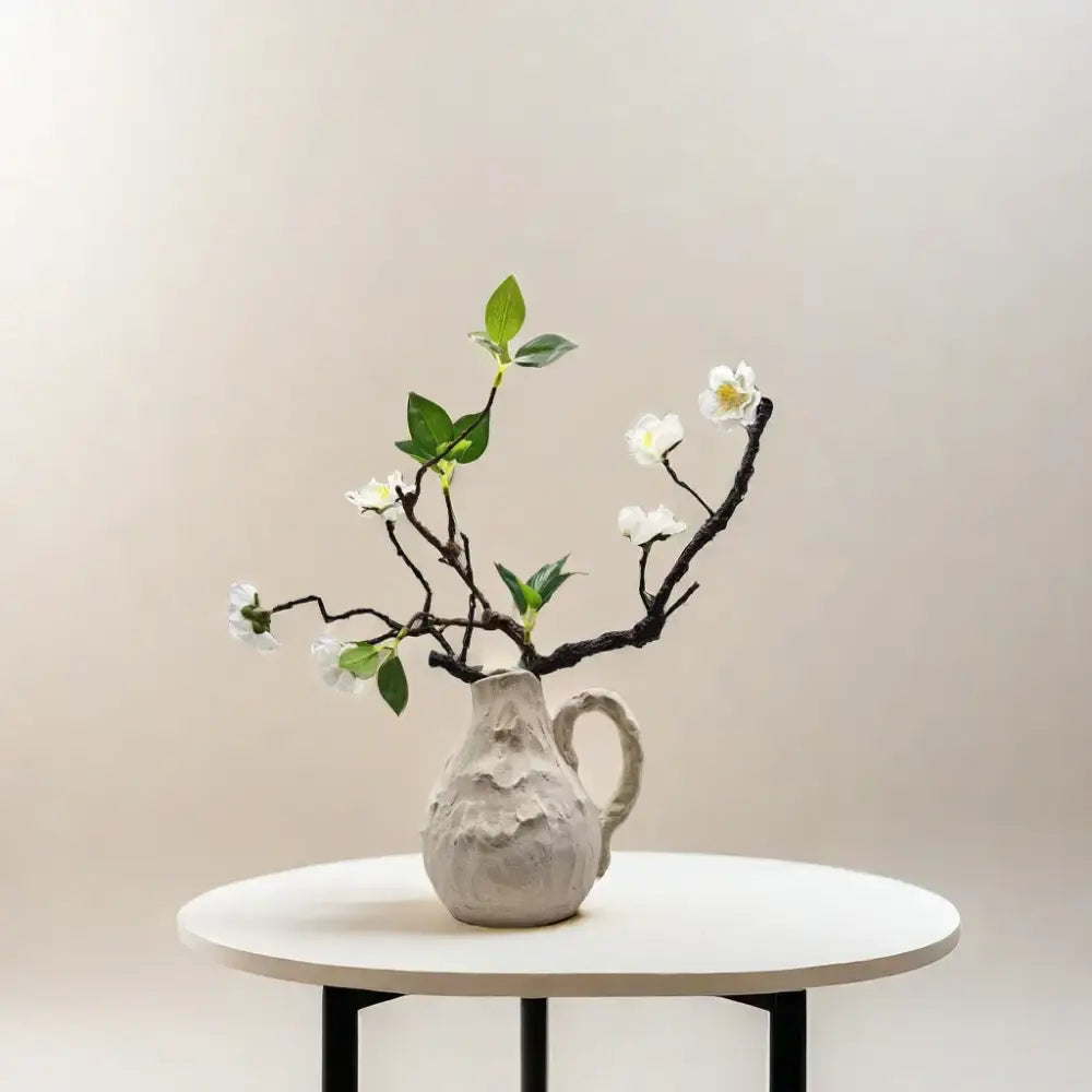 Off-white decorbites handmade irregular grain ceramic pitcher vase with matte gray finish holding white blossoms for living room decor
