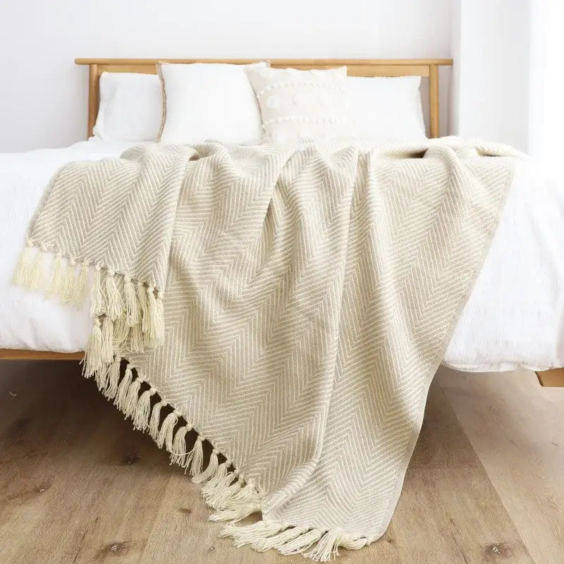 Cream-colored woven throw blanket with herringbone pattern and tassels for decorbites geometric knitted blanket decor