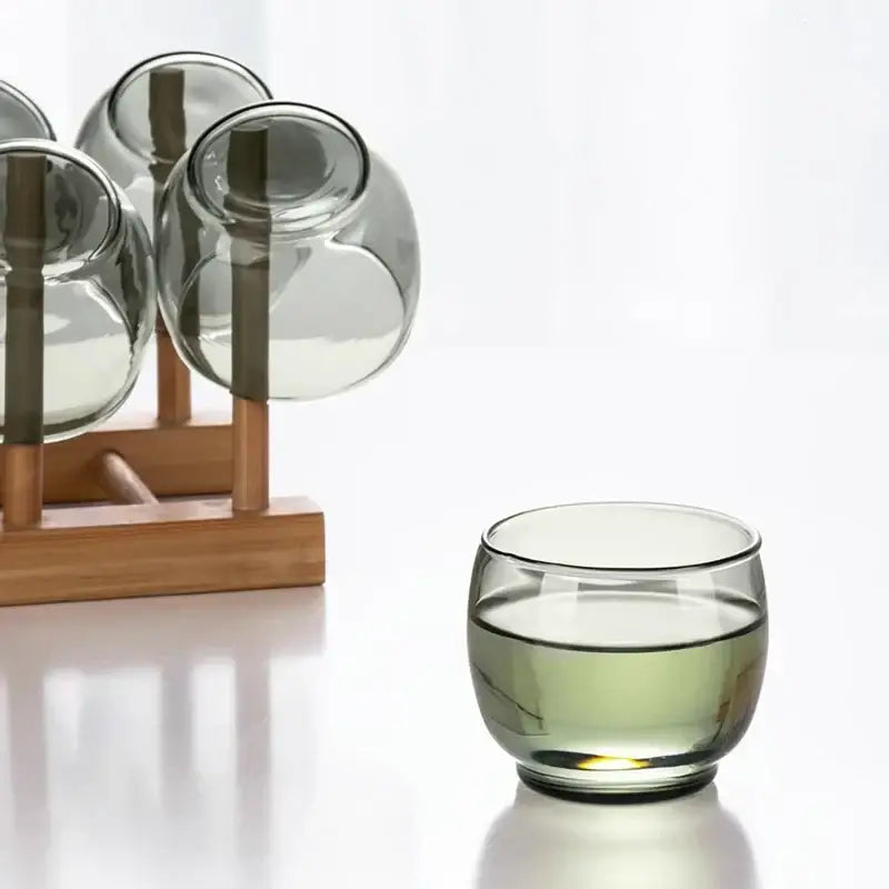 Olive green glass tea cup set featuring a translucent glass tea cup with light-colored tea for dining room kung fu tea decorbites glass tea