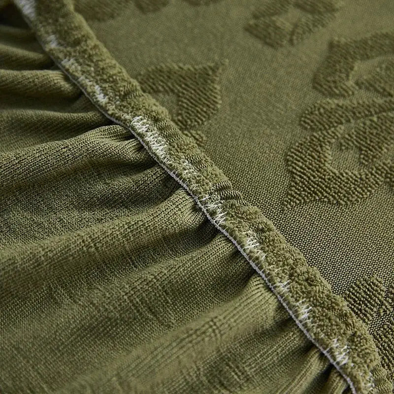 Olive green patterned jacquard sofa seat cover with textured leaf design and frayed white-trimmed edge for living room protector