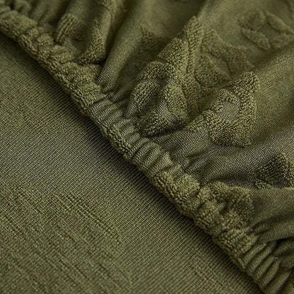 Olive green jacquard sofa seat cover with textured cable knit pattern and elasticated waistband for living room protection