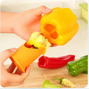 Orange plastic vegetable cutter corer seed remover removing seeds from a yellow bell pepper in kitchen use