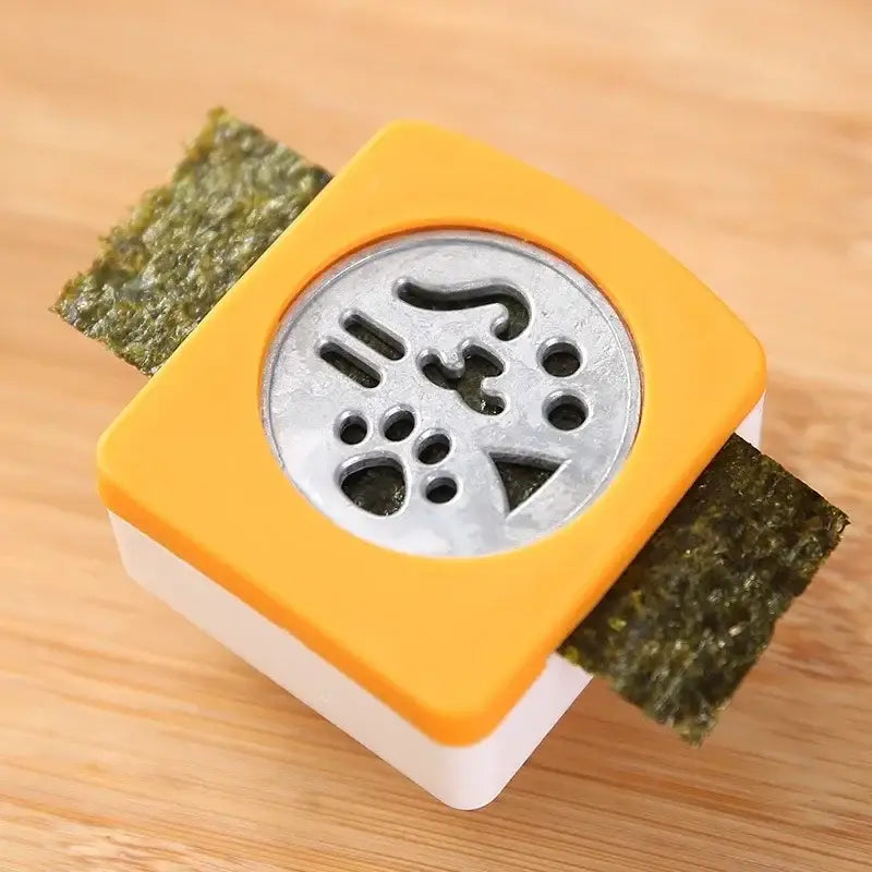 Bright orange and white plastic decorbites cat shape onigiri maker with silver metal stamp featuring intricate cat design