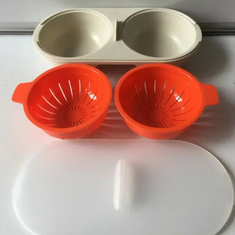 Orange and white silicone egg boiler steamer double cup with radial slits and side handles for easy egg separation