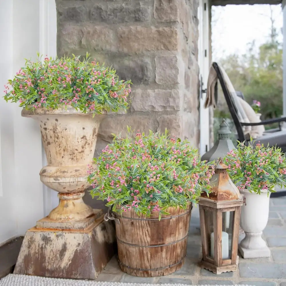 Weathered stone urn with lush greenery and pink flowers featuring orange babysbreath lover fruit artificial plant decor