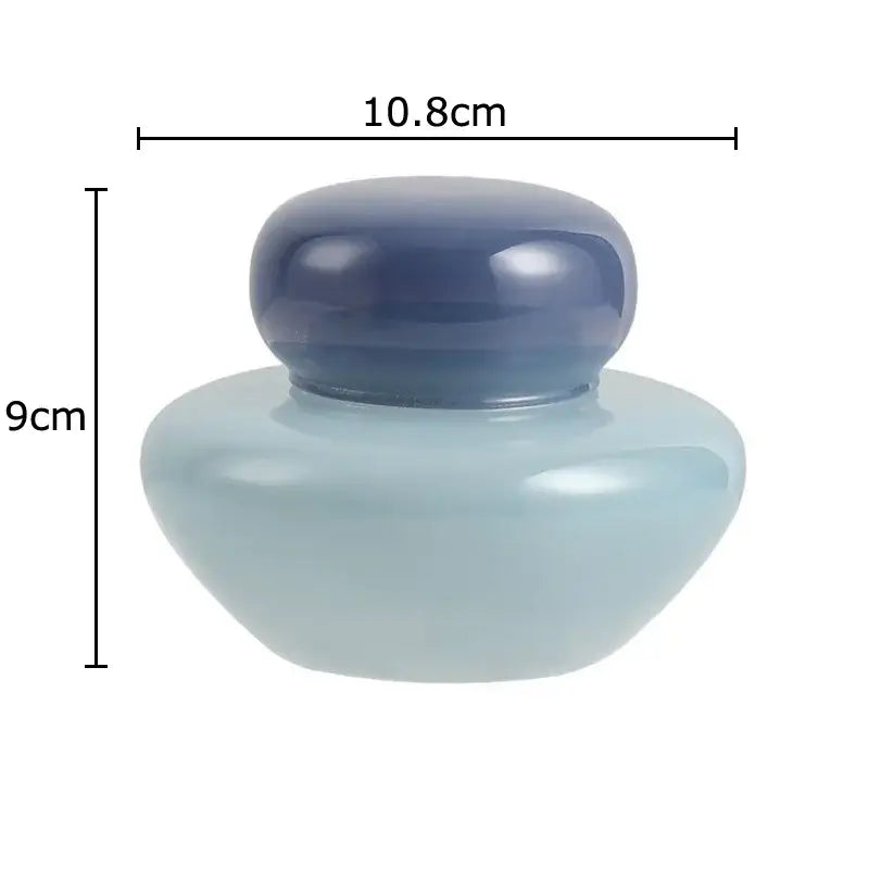 A sleek translucent light blue ceramic storage jar with a matching dark blue lid for kitchen glass storage
