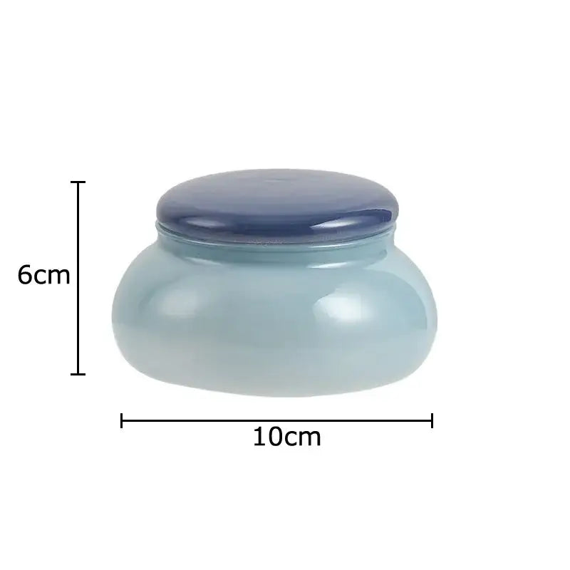 A smooth translucent light blue ceramic storage jar with a dark blue lid for kitchen glass storage and candy pot use