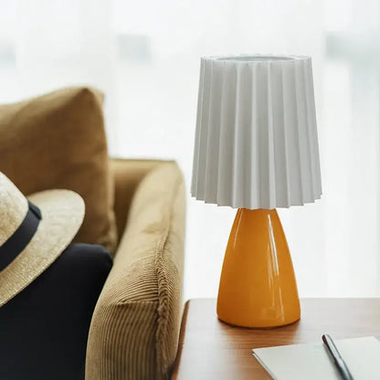 A modern orange ceramic milkshake bedside lamp with a glossy base and white pleated fabric shade for bedroom decorbites ceramic milkshake