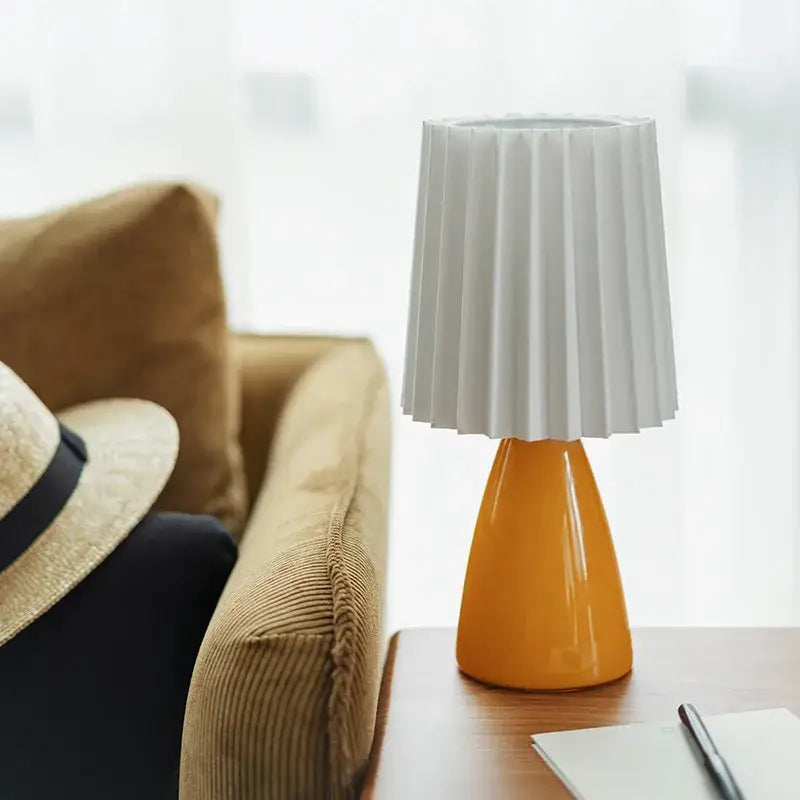 A modern orange ceramic milkshake bedside lamp with a glossy base and white pleated fabric shade for bedroom decorbites ceramic milkshake