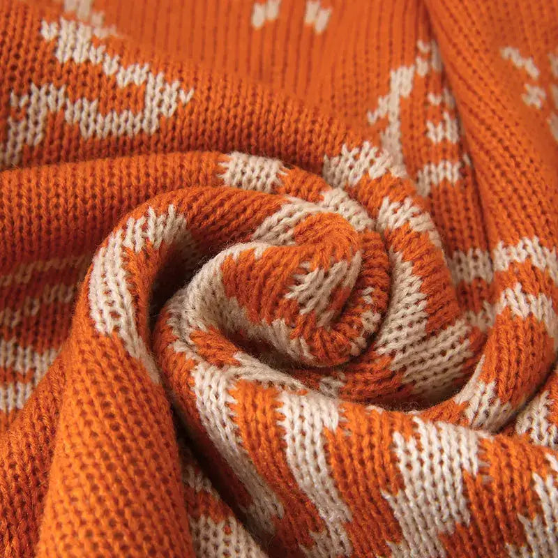 A cozy orange and cream knitted scarf featuring the festive decorbites cashew pattern for stylish warmth