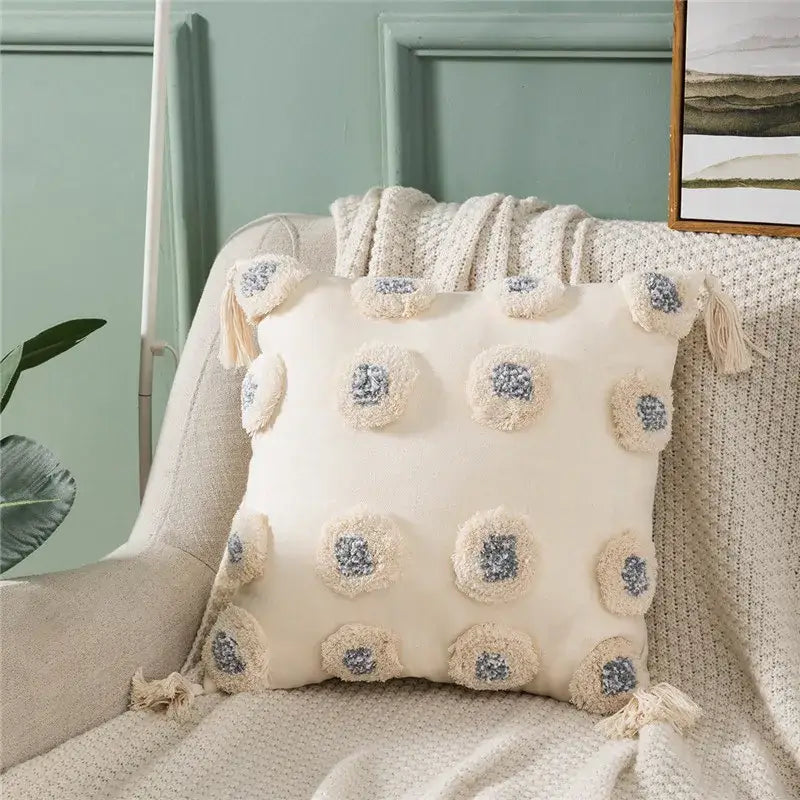 Cream-colored cushion cover with fluffy pom-poms and tassels featuring soft texture and decorbites heart embroidery design