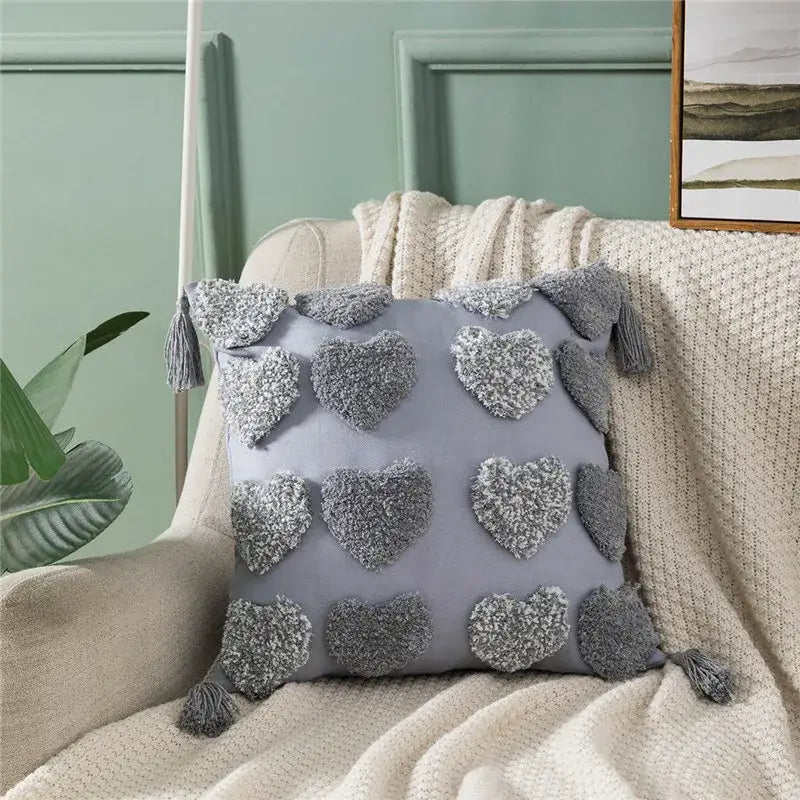 Gray plush cushion cover with decorbites heart embroidery textured pom-poms and matching tassels for living room decor