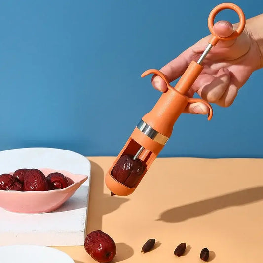 Orange metal cherry pitter fruit core remover with ring handle and dual grips for easy red date pit removal