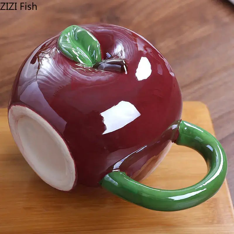 A glossy red ceramic fruit ceramic cup shaped like an apple with a green handle for kitchen breakfast decorbites colorful fruit