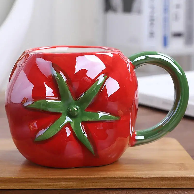 Vibrant red colorful fruit ceramic cup shaped like a tomato with green leafy stem for kitchen breakfast decorbites