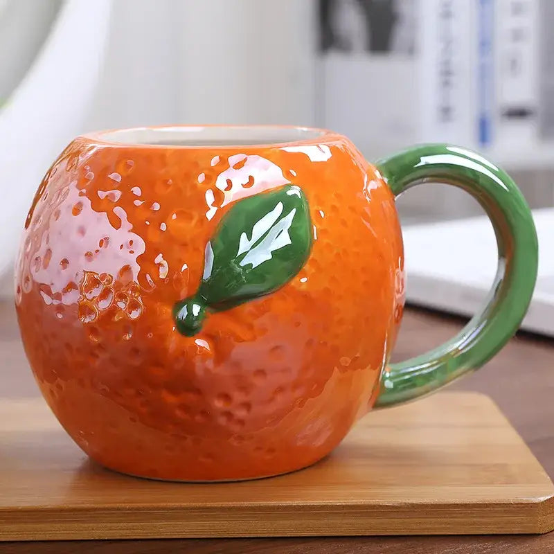 Vibrant orange pumpkin fruit ceramic cup with textured peel and green leaf accent for decorbites colorful fruit collections
