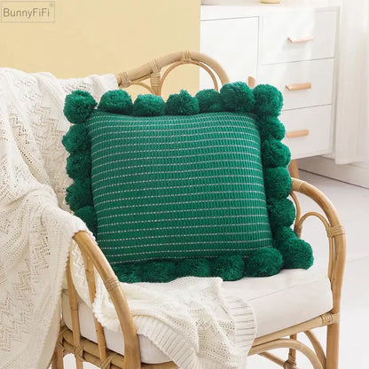 Emerald green knitted ball cushion cover with fluffy pom-pom trim and subtle white dotted pattern for living room decor