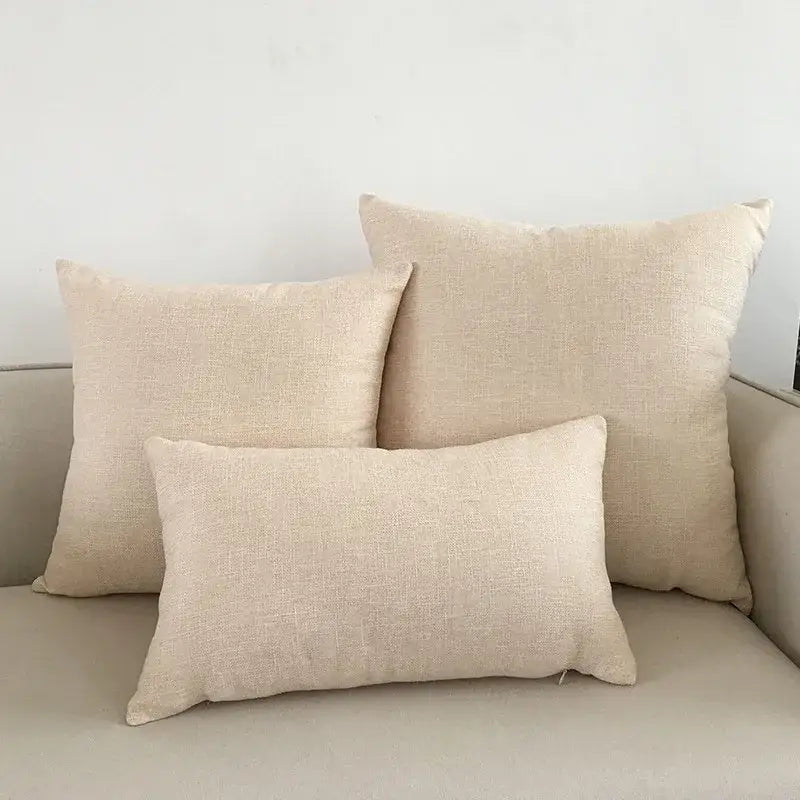 Three beige linen cushion covers of varying sizes arranged on a light decorbites ivory sofa cushion for living room decorbites ivory sofa