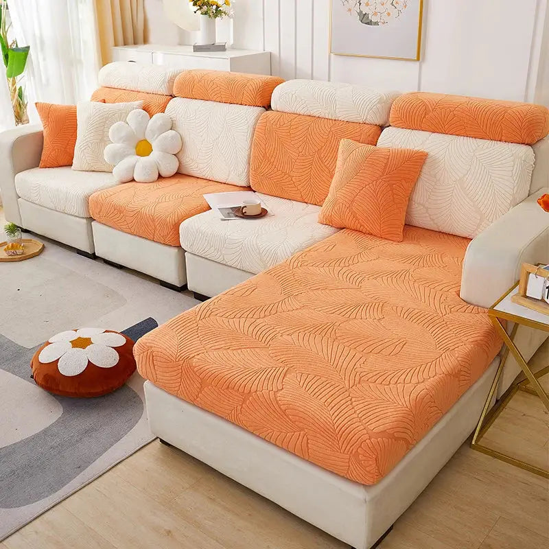 Orange quilted fabric sofa cover with white textured back cushions featuring a leaf jacquard pattern for living room protection