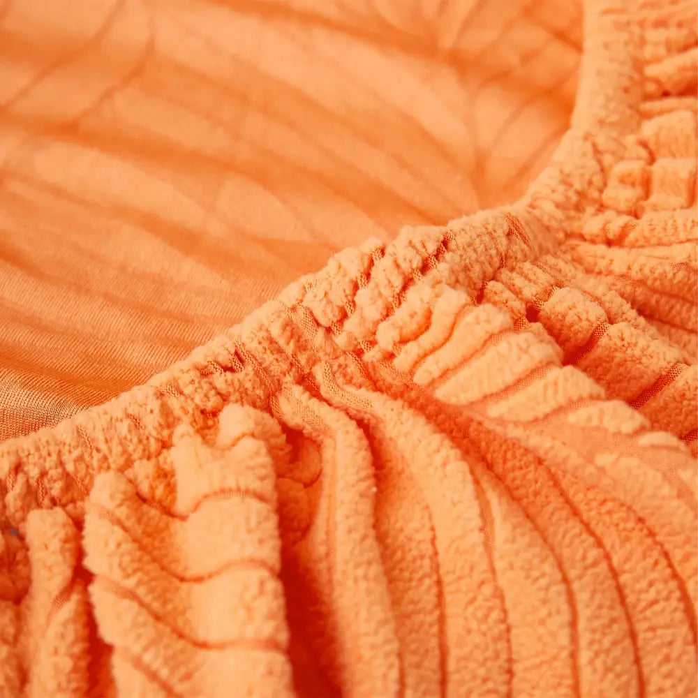 Orange and white leaf jacquard stretch sofa cover with orangish orange corduroy ribbed fabric and elasticated waistband