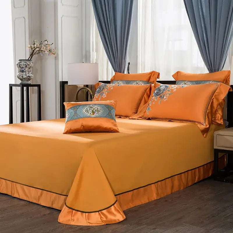 Orange satin bedding set with embroidered floral accents and ruffled hem made of 200s embroidery egyptian cotton