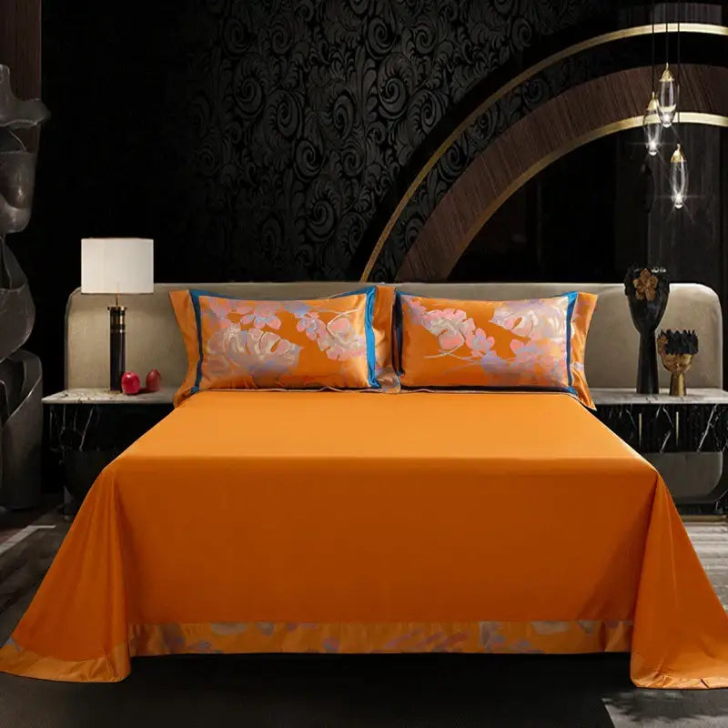 Vibrant orange satin bedding set with floral embroidery and blue-trimmed pillowcases in egyptian cotton silk jacquard