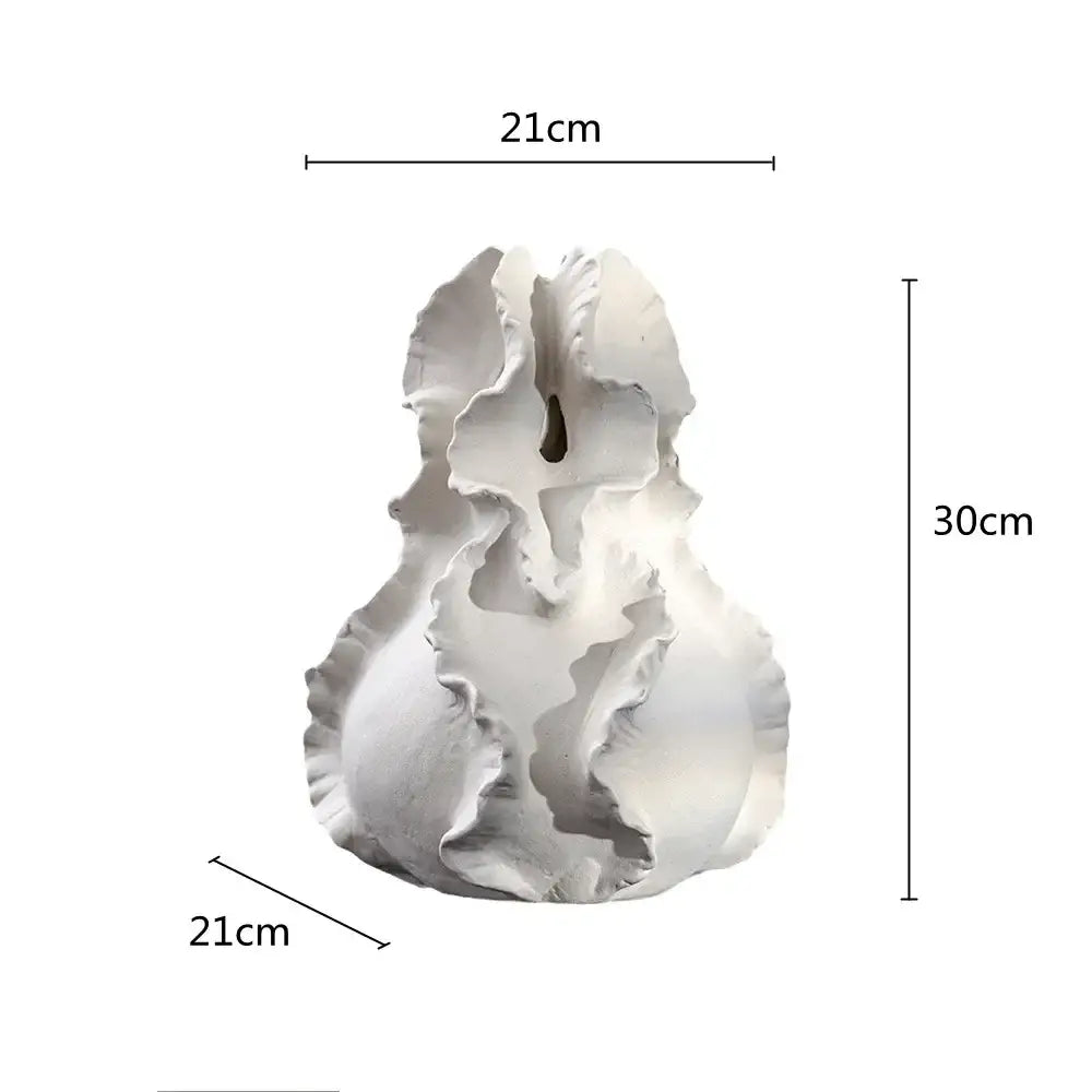A white ceramic wavy flower vase with ruffled layered petals and a central opening for decorbites ceramic wavy decor