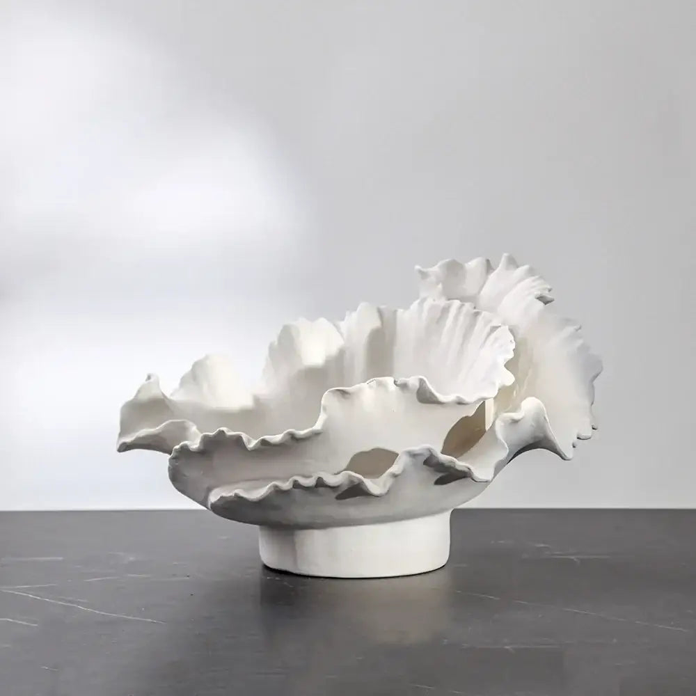 A white ceramic wavy flower vase with a ruffled leaf-like rim from decorbites for living room decor and storage
