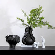 Black ceramic wavy flower vase with organic ruffled texture and tall green fern arrangement for living room decorbites ceramic wavy decor