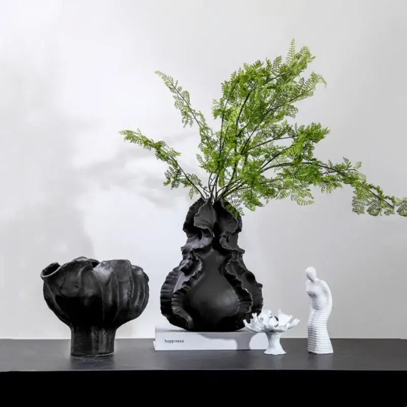Black ceramic wavy flower vase with organic ruffled texture and tall green fern arrangement for living room decorbites ceramic wavy decor