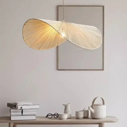 A warm glowing handmade rattan led pendant light with twisted fan-shaped shade in organic golden brown decorbites style