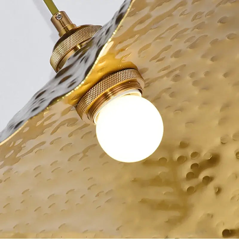 Organic golden iron lotus leaf pendant light with gold-toned hammered brass shade and exposed bulb for dining room decorbites golden iron