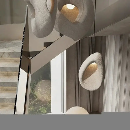 Modern organic gray textured stone pendant lights with matte finish and warm interior lighting for dining room decorbites designer led