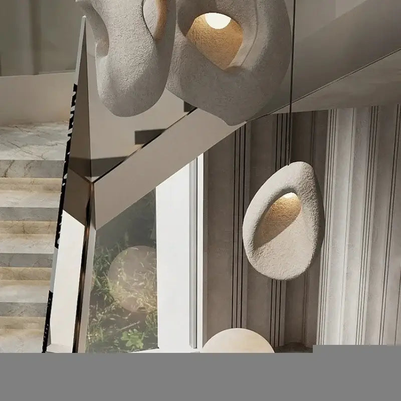 Modern organic gray textured stone pendant lights with matte finish and warm interior lighting for dining room decorbites designer led