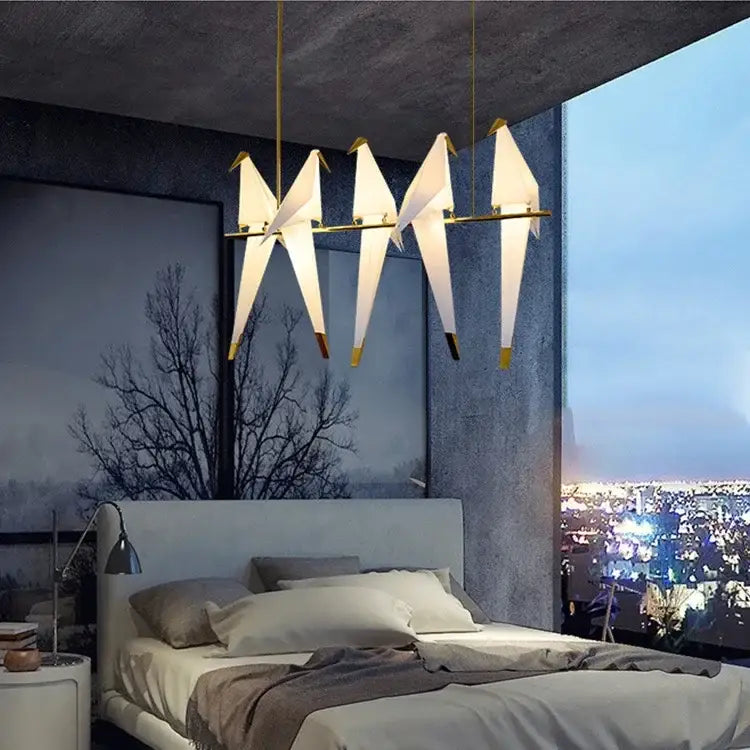 Elegant white and gold origami crane chandelier iron led lights from decorbites hang above the bedroom bed
