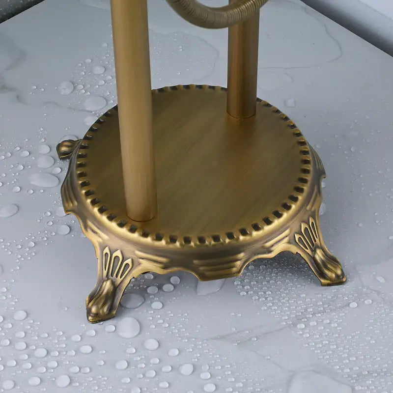 Ornate antique brass freestanding bathtub filler with handshower featuring claw-footed base and decorative beaded edge